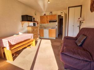 a living room with a couch and a table at Studio calme avec terrasse jardin et parking - 4 pers. - FR-1-505-11 in Notre-Dame-de-Bellecombe