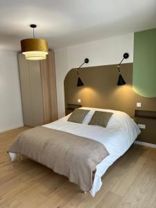 a bedroom with a large white bed with two lamps at Le K Appartement - Strasbourg in Strasbourg