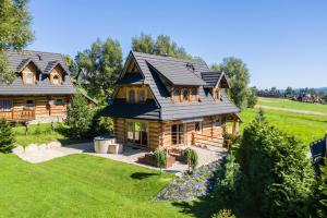 una casa de madera con techo de gambrel en Dom Bajeczna Polana Jacuzzi, en Kościelisko