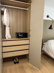 ein Schlafzimmer mit einem Schrank mit einer Kommode und einem Bett in der Unterkunft Le K Appartement - Strasbourg in Straßburg