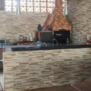 uma cozinha com um balcão e uma parede de tijolos em Sobrado lindo em Campo Grande