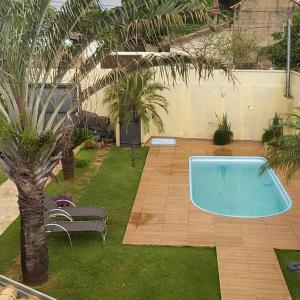 einen Pool im Garten mit Palmen in der Unterkunft Sobrado lindo in Campo Grande
