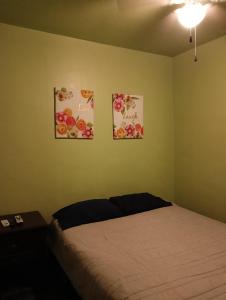 1 dormitorio con 1 cama y 3 cuadros en la pared en Hospedaje JrzConsulado en Ciudad Juárez