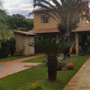 una casa con una palmera en el patio en Sobrado lindo, en Campo Grande