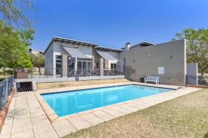 a swimming pool in front of a house at V&S Apartments - Luxury Studio in Fourways, Johannesburg in Sandton +15 photos