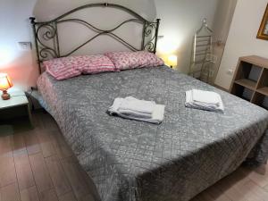 a bedroom with a bed with towels on it at House of terme bilocale a due passi dalle terme di rapolano in Rapolano Terme