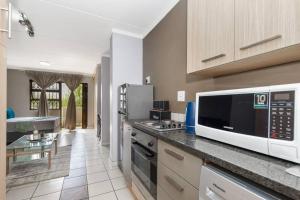 a kitchen with a microwave and a counter top at V&S Apartments - Luxury Studio in Fourways, Johannesburg in Sandton