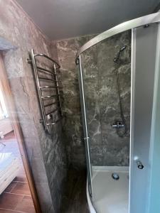 a shower with a glass door in a bathroom at Котедж GLORIA будинок повністю in Yaremche +46 photos