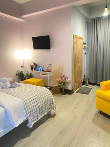 a bedroom with a bed and a tv on the wall at Triple J hotel Trang in Trang