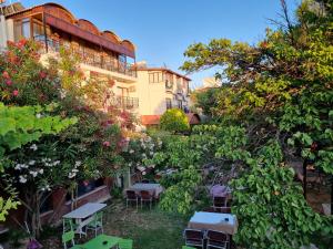 a garden with tables and chairs in front of a building at Soleil Hotel in Kuşadası