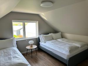 1 dormitorio con 2 camas y ventana en Urriðafoss Waterfall Villa, en Selfoss