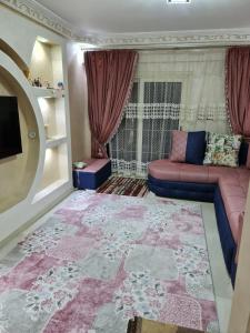 ein Wohnzimmer mit einem Sofa und einem großen Teppich in der Unterkunft Beautiful Old Apartment in Madinat Al Ashir min Ramadan