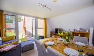 a living room with a dining room table and a couch at Escape to a Clifftop Chalet with pool and tennis onsite - 1A Kingsdown Holiday Park in Kingsdown