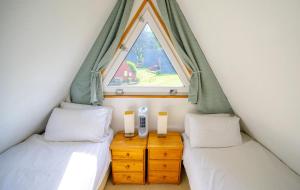 two twin beds in a small room with a window at Escape to a Clifftop Chalet with pool and tennis onsite - 1A Kingsdown Holiday Park in Kingsdown +43 photos