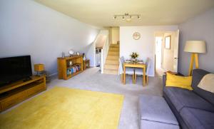 a living room with a couch and a tv and a table at Escape to a Clifftop Chalet with pool and tennis onsite - 1A Kingsdown Holiday Park in Kingsdown