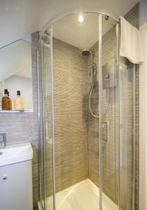 a shower with a glass door in a bathroom at Escape to a Clifftop Chalet with pool and tennis onsite - 1A Kingsdown Holiday Park in Kingsdown