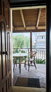 Une porte ouverte s'ouvre sur une terrasse avec une table et des chaises. dans l'établissement Villa Rossella, à Scafati