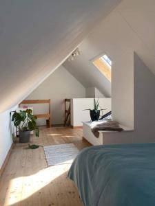 un dormitorio en el ático con una cama y plantas. en Christina, en Aalborg