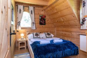 ein Schlafzimmer mit einem Bett in einem Blockhaus in der Unterkunft Dom Bajeczna Polana Jacuzzi in Kościelisko