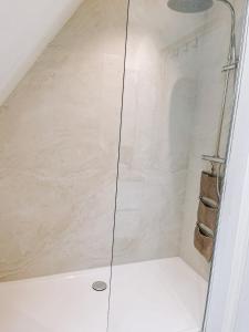 um chuveiro com uma porta de vidro na casa de banho em Cozy Guesthouse em Bruges