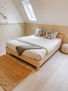 um quarto com uma cama grande com lençóis brancos e almofadas em Cozy Guesthouse em Bruges