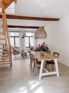 uma sala de jantar com uma mesa de madeira e cadeiras em Cozy Guesthouse em Bruges