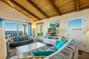 sala de estar con sofá y TV en Beach Retreat -- Upper Retreat en Newport