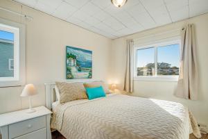 1 dormitorio con 1 cama y 2 ventanas en Beach Retreat -- Upper Retreat en Newport