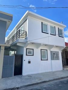 uma casa branca com uma varanda e uma entrada em 1058 Modern Hotel em San Juan