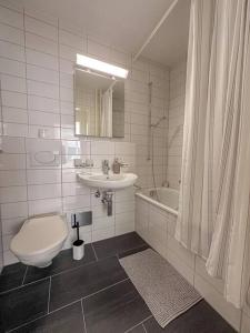 Modern 2-Bedroom Apartment in City Centre في بازل: حمام مع مرحاض ومغسلة وحوض استحمام