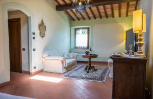 a living room with a chair and a table at Castel Pietraio WineResort in Monteriggioni +60 photos