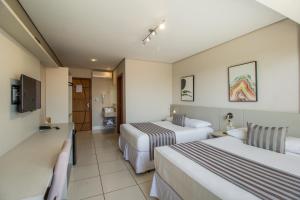 um quarto de hotel com duas camas e uma televisão em Pousada Molinha em Penha