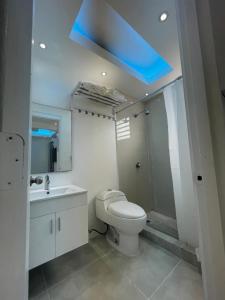 a bathroom with a toilet and a blue ceiling at 1058 Modern Hotel in San Juan