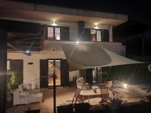 d'une terrasse avec une table et un parasol blanc. dans l'établissement Villa Rossella, à Scafati