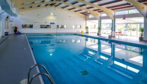a large swimming pool in a building at Escape to a Clifftop Chalet with pool and tennis onsite - 1A Kingsdown Holiday Park in Kingsdown