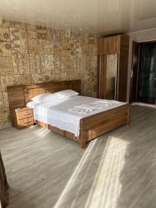 a bedroom with a large bed with a wooden frame at villa with beautiful view 2 in Tbilisi City