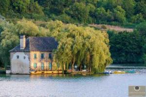 a house on a island in the middle of a lake at Joli appartement à Brive la gaillarde in Brive-la-Gaillarde