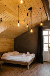a bedroom with a bed in a wooden room with lights at Hotel Dynasty in Kamianets-Podilskyi