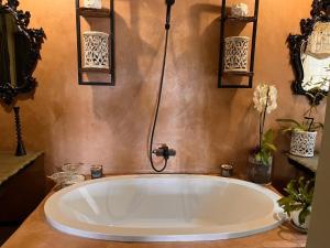 una grande vasca bianca in un bagno con fiori di A Bird Cage Stay & Cottage a Haenertsburg Altre 30 foto