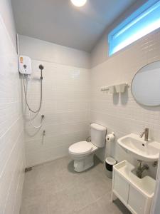 W łazience znajduje się toaleta, umywalka i lustro. w obiekcie Triple J hotel Trang w mieście Trang