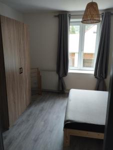 1 dormitorio con cama, ventana y puerta en appt F3 - La Bresse/Cornimont, en Cornimont