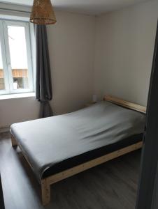 Bett in einem kleinen Zimmer mit Fenster in der Unterkunft appt F3 - La Bresse/Cornimont in Cornimont