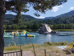 un grupo de toboganes inflables y un parque infantil en un lago en appt F3 - La Bresse/Cornimont, en Cornimont