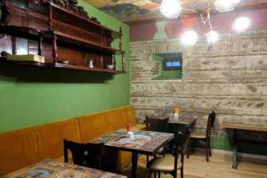 un restaurante con mesas y sillas y una pared verde en Erekle II en Telavi