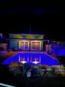 uma piscina em frente a uma casa à noite em Holiday cottage-vakantiehuis-vikendica em Zolaći