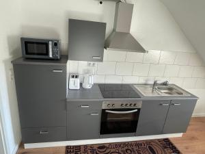 a small kitchen with a sink and a microwave at Ferienwohnung Rastatt in Rastatt