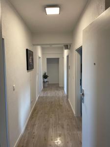 an empty hallway of an apartment with wood floors at Ferienwohnung Rastatt in Rastatt