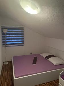 um quarto com uma cama roxa e um computador portátil em Holiday cottage-vakantiehuis-vikendica em Zolaći