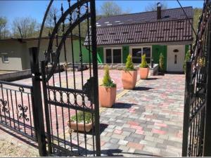 um portão em frente a uma casa com vasos de plantas em Holiday cottage-vakantiehuis-vikendica em Zolaći