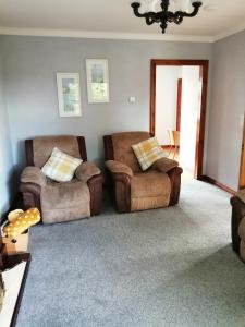 a living room with two chairs and a couch at Lynn's Lodge in Randalstown